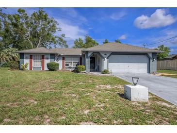 Charming single-story home with an attached two-car garage and a well-manicured lawn at 3009 Ainsworth Ave, Spring Hill, FL 34609