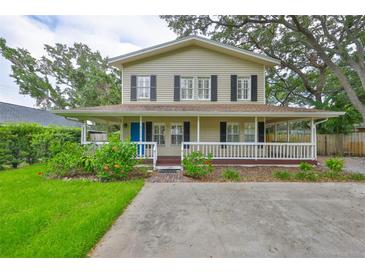 Charming two-story home featuring a welcoming wrap-around porch and nicely landscaped front yard at 3906 W San Luis St, Tampa, FL 33629