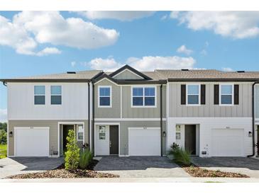 New townhomes show modern exteriors with driveways and landscaping under a sunny sky at 7678 Deer Valley Circle, Tampa, FL 33635