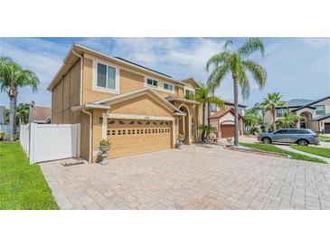 Two-story home showcasing a neutral color scheme, two-car garage, a paver driveway and mature landscaping at 1205 Sweet Gum Dr, Brandon, FL 33511