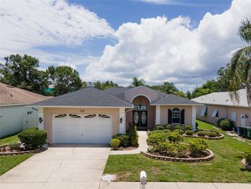 Charming single-story home featuring a well-maintained lawn and inviting curb appeal at 1716 Bermuda Ct, Safety Harbor, FL 34695