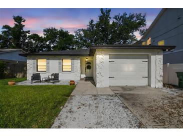 Charming home featuring a well-manicured lawn, textured exterior, and cozy front patio seating at 206 N Beverly Ave # 1/2, Tampa, FL 33609