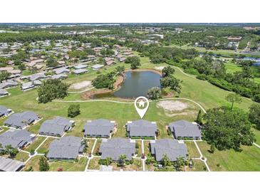 This aerial view showcases a well-maintained community with lush landscaping and serene pond views at 301 Canton Ct # 77, Sun City Center, FL 33573