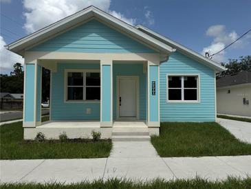 Charming single-story home with a delightful blue exterior and freshly cut lawn at 4200 N 15Th St, Tampa, FL 33610