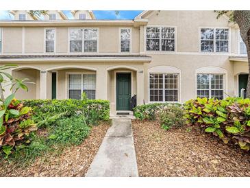 Charming townhouse featuring a stucco facade, lush landscaping, and inviting entryway at 4668 66Th N Pl, Pinellas Park, FL 33781