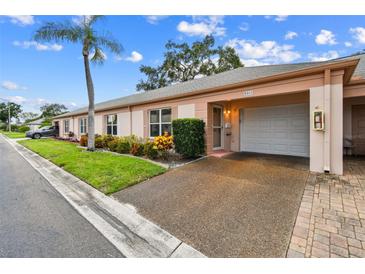 Charming single-story home with an attached garage, well-manicured lawn, and colorful landscaping at 8319 Annwood Rd, Seminole, FL 33777