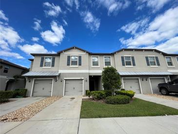 Well-maintained townhome with attached garages, beautiful landscaping, and a manicured lawn at 9768 Pembrooke Pines Dr, Sun City Center, FL 33573