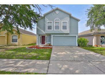 Charming light blue two-story home with a well-manicured lawn and an attached two-car garage at 11438 Ivy Flower Loop, Riverview, FL 33578