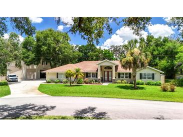 Charming single-story home with well-manicured lawn, palm trees, and a spacious driveway at 11945 Darwin Ave, New Port Richey, FL 34654