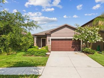 Inviting single-Gathering home featuring a well-maintained lawn and an attached two-car garage at 1325 Custer Bayou St, Ruskin, FL 33570