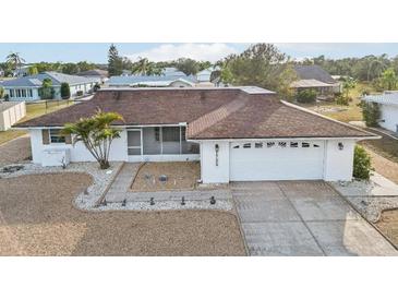 Charming home featuring a well-maintained front yard, a screened porch, and an attached two-car garage at 1732 Flamingo Ln, Sun City Center, FL 33573