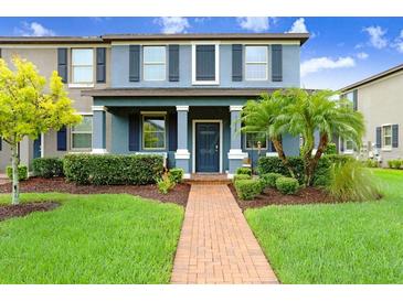 Charming two-story townhome featuring a well-manicured lawn and beautiful landscaping at 17378 Cruiser Bnd, Land O Lakes, FL 34638