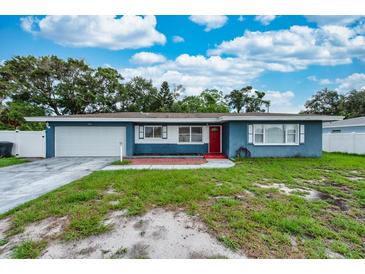 Charming single-story home with a well-manicured lawn and bright red door at 1800 Pine St, Clearwater, FL 33764