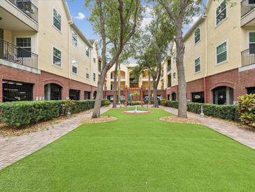 Beautiful courtyard featuring lush green space, manicured landscaping, and a charming water feature at 2010 E Palm Ave # 14303, Tampa, FL 33605