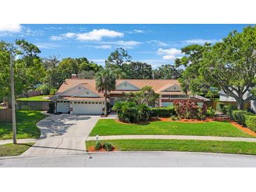 Beautiful single-Gathering home with lush landscaping, mature trees, and a well-maintained lawn at 512 Crystal Grove Blvd, Lutz, FL 33548