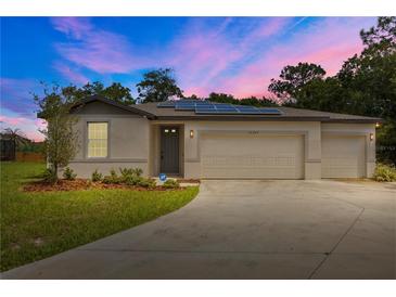 Charming single-Gathering home featuring a three-car garage, solar panels, and a well-manicured lawn at 12277 Spring Hill Dr, Spring Hill, FL 34609