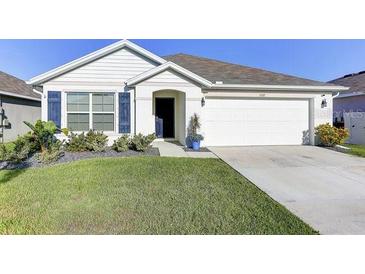 Charming single-story home featuring manicured lawn and a two-car garage at 1332 Ocean Spray Dr, Ruskin, FL 33570