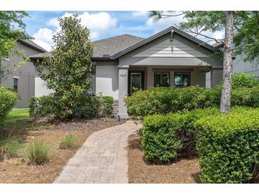 Charming single-story home with lush landscaping and a brick walkway leading to the front door at 3037 Riders Pass, Odessa, FL 33556