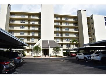 Exterior view of a multi-story building with covered parking and well-maintained landscaping at 3200 Cove Cay Dr # 5F, Clearwater, FL 33760