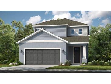Charming two-story home showcasing a modern design and neutral color palette, complemented by a well-manicured lawn at 723 Steel Dr, Apollo Beach, FL 33572