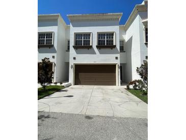 Townhome featuring a two-car garage and bright, white exterior at 8405 Costa Bella Way, Temple Terrace, FL 33637