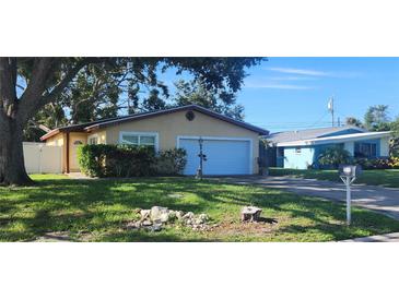 Charming single-story home with mature trees and a well-maintained lawn at 10502 Orange Blossom Ln, Seminole, FL 33772