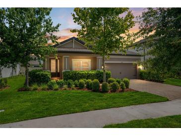 Charming single-Gathering home featuring manicured landscaping, a brick driveway, and a welcoming front porch at 11881 Ranchers Gap Dr, Odessa, FL 33556