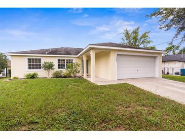 Charming one-story home featuring a two-car garage, manicured lawn, and vibrant landscaping at 13384 Brighton St, Spring Hill, FL 34609