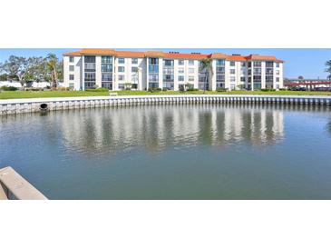 Waterfront condo building with orange tile roof reflected in the water at 19029 Us Highway 19 N # 8-31, Clearwater, FL 33764