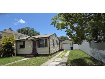 Cozy single-Gathering home featuring neutral siding, a well-maintained lawn, and a detached single-car garage at 3131 Melton N St, St Petersburg, FL 33704