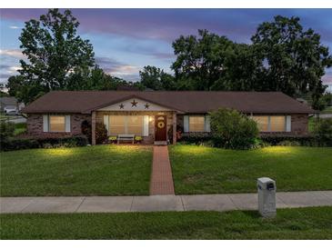 Charming single-story brick home with a well-manicured lawn and inviting front porch at 37821 Willingham Ave, Dade City, FL 33525