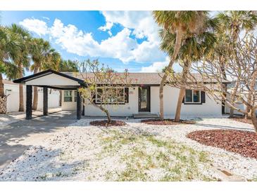 Charming home with tropical landscaping, white rock and palm trees creating a serene curb appeal at 463 85Th Ave, St Pete Beach, FL 33706