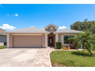 Charming single-story home featuring a two car garage, brick walkway, and well maintained lawn at 6351 Desert Peace Ave, Land O Lakes, FL 34639