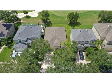 An aerial view of a well-manicured home next to a golf course and perfectly manicured lawn at 10559 Coral Key Ave, Tampa, FL 33647