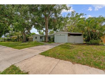 Charming single-story home with a well-maintained lawn and mature trees providing shade at 1309 11Th W Ave, Palmetto, FL 34221