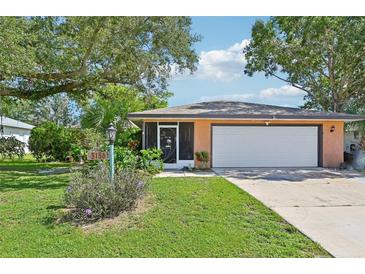 Charming single-story home with a well-maintained lawn, mature trees, and a convenient attached two-car garage at 3156 Depew Ave, Port Charlotte, FL 33952