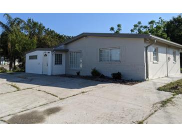 Charming single-story home with a well-maintained exterior, spacious driveway, and a light gray facade at 4802 Drift Tide Dr, New Port Richey, FL 34652