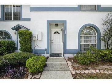 Inviting front entrance with a white door, trimmed in blue and complemented by lush landscaping at 603 Bainbridge Dr, Brandon, FL 33511