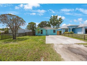 Charming single-story home featuring a blue exterior, well-maintained lawn, and a spacious driveway at 6704 70Th N Ave, Pinellas Park, FL 33781