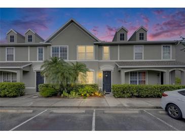 Charming townhome featuring manicured landscaping, a well-lit walkway, and neutral exterior paint at 13905 Abbey Ln, Largo, FL 33771