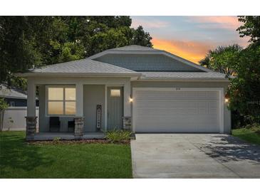 Charming single-Gathering home featuring a two-car garage, welcoming front porch, and manicured lawn at 3114 E 21St Ave, Tampa, FL 33605