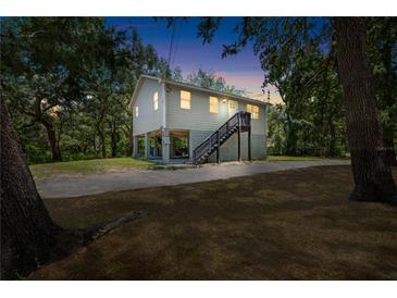 Charming two-story home on stilts with a well-maintained yard and stairs to front door at 34147 Ringwalt Dr, Dade City, FL 33523