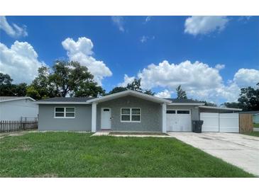 Charming single-story home featuring a stone facade, well-maintained lawn, attached garage and driveway at 3803 43Rd N Ave, St Petersburg, FL 33714