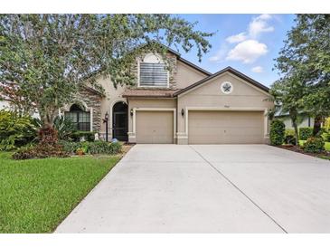 Charming two-story home with a three car garage, stone accents, and well-manicured lawn at 5962 Lexington Dr, Parrish, FL 34219