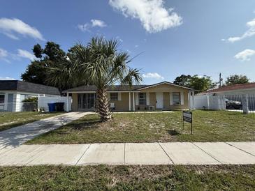 Charming single-story home with a well-manicured lawn and a large palm tree in the front yard at 7206 Reindeer Rd, Tampa, FL 33619