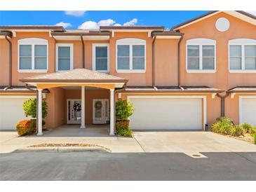 Charming townhouse with a two-car garage and lovely landscaping under a bright blue sky at 829 Date Palm Ln, St Petersburg, FL 33707