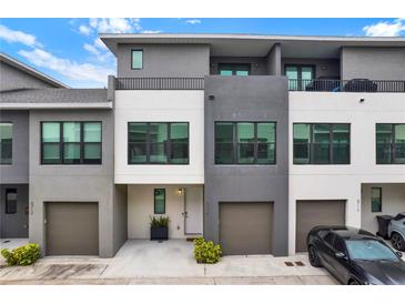 Contemporary townhome featuring neutral color palette, private balconies, and attached garages for convenient parking at 8714 Palm Ranches Pl, Tampa, FL 33614