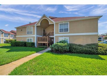 Inviting tan condo building featuring well-maintained landscaping and a welcoming walkway at 9481 Highland Oak Dr # 806, Tampa, FL 33647