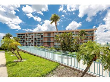 Beautiful multi-story condo building with palm trees and blue sky view at 1 Key Capri # 606W, Treasure Island, FL 33706