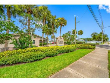 Community sign surrounded by lush greenery and palm trees under a bright blue sky at 2131 Ridge S Rd # 19, Largo, FL 33778